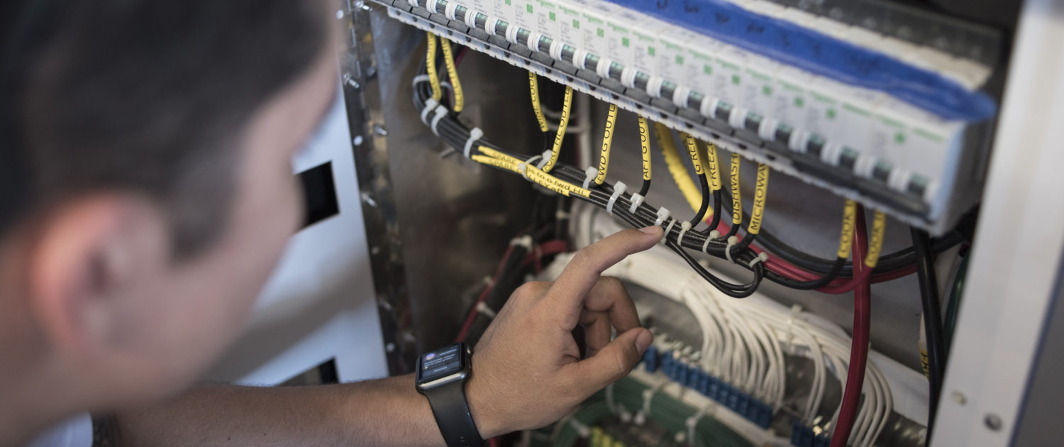 Young electrician repairing boat control