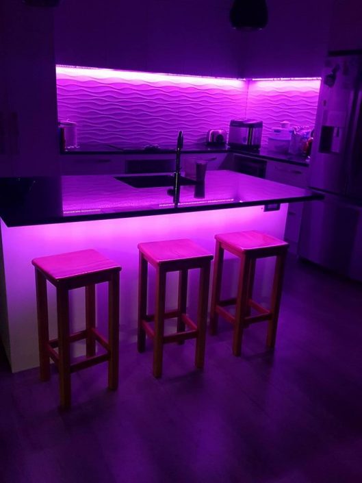 Purple lit kitchen with backlight on wall