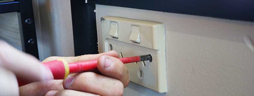 Electrician fixing a plug socket